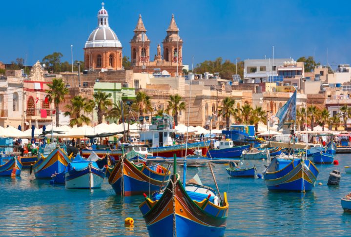 Traditional eyed colorful boats Luzzu in the Harbor of Mediterranean fishing village Marsaxlokk, Malta