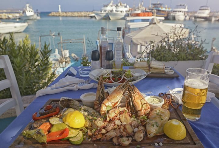 A summer  dinner .Unidentified people eating traditional delicious mediterranean dish  outdoor restaurant  in Cyprus , Ayia-napa.Tasty and authentic cypriot kitchen