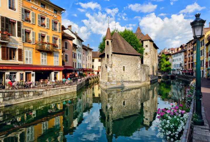 ANNECY, FRANCE - JUNE 22: People drink coffee near the River Thiou in Old Town, encircling the medieval palace perched mid-river - the Palais de l'Isle on June 22, 2014 in Annecy, France.